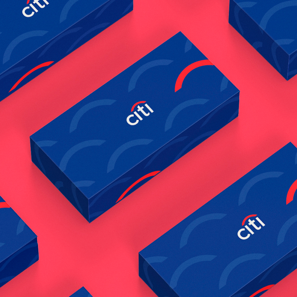 Design As A Subscription 7 Blue gift boxes with a pattern of semicircles and the word citi are arranged on a pink surface. Each box features a red arc above the brand name, showcasing an eye-catching design subscription style.